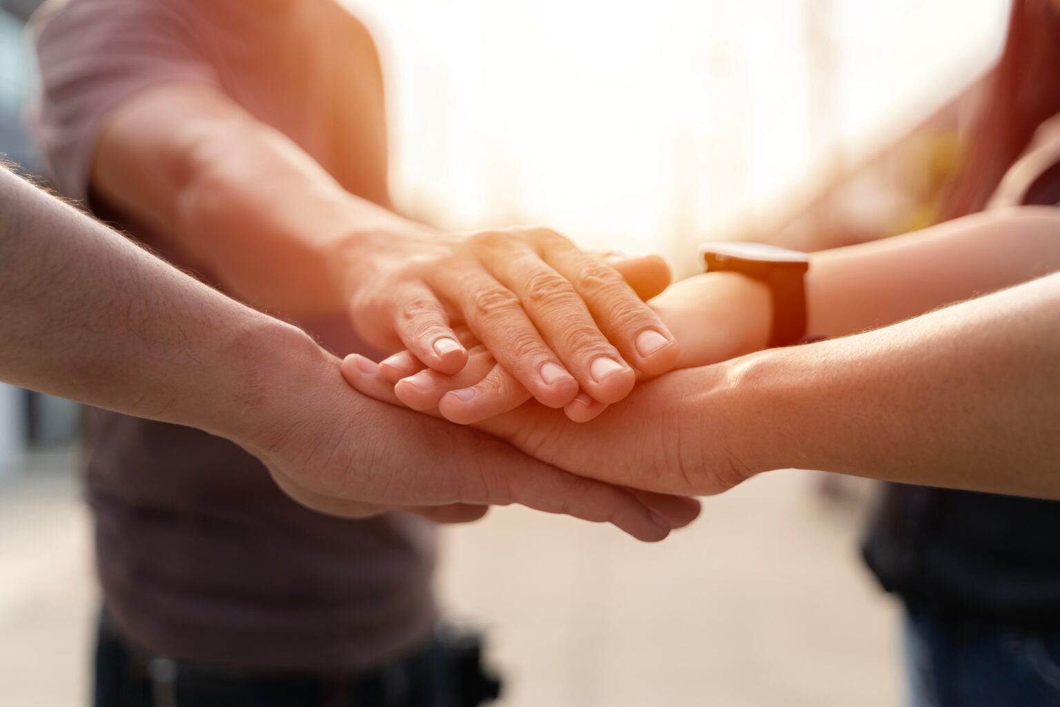 people,joining,hands,in,the,middle.successful,multiracial,businesspeople,reach,business